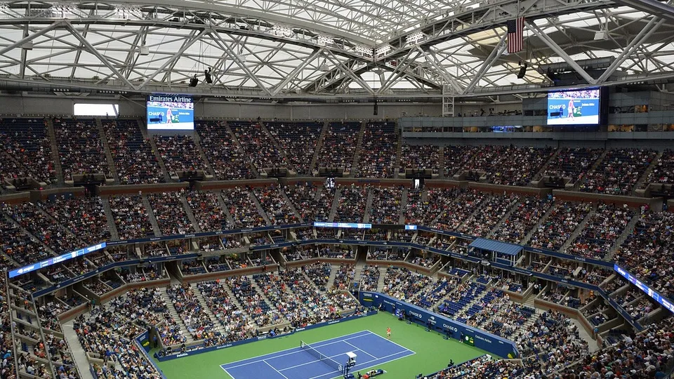 Arthur Ashe Stadium lotado, com a quadra dura azul do US Open e o teto retrátil fechado